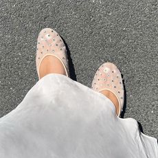 ana wears white skirt and white mesh flats with rhinestones on them 